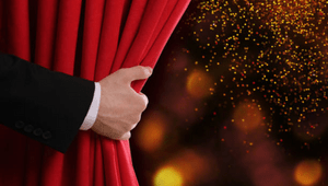 main qui ouvre un rideau rouge de theatre pour symboliser l'histoire et les valeurs de la compagnie de theatre acour